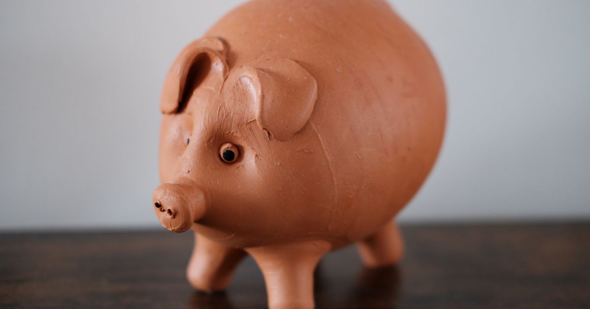 A terracotta piggy bank on a wooden table
